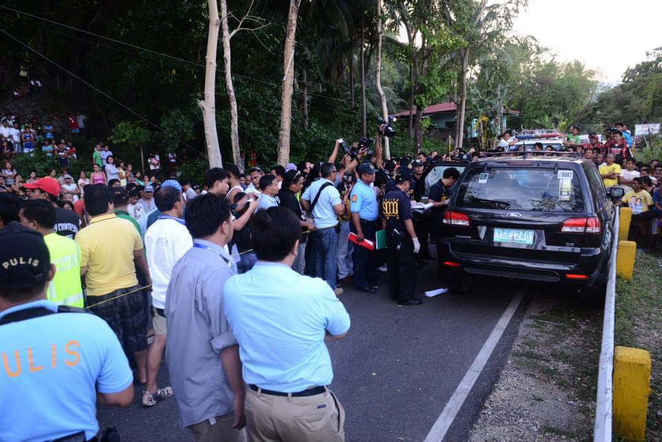 Police go over the vehicle lawyer Noel Archival was riding when he was ambushed and killed in Dalaguete. (Photo by Mark Luzano)
