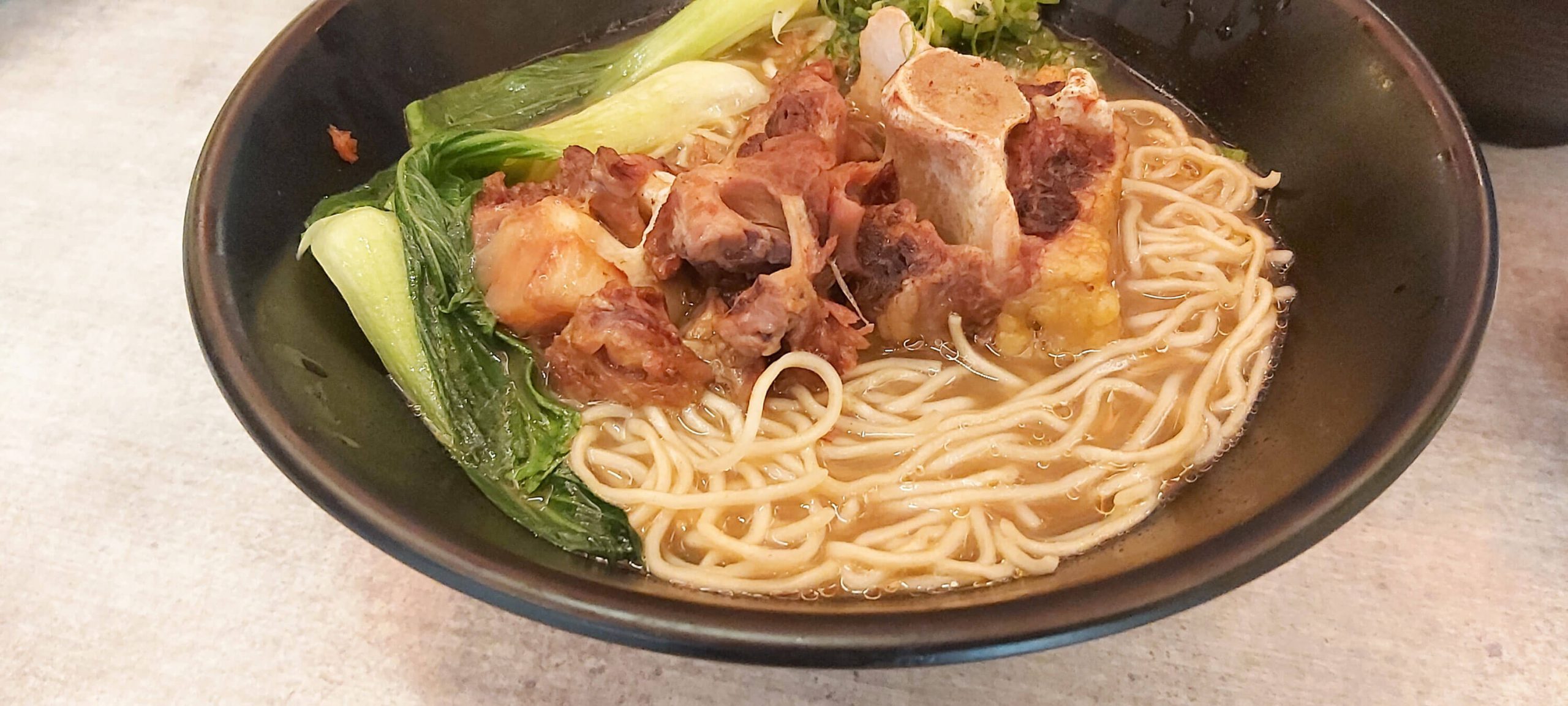 OXTAIL RAMEN. This dish has oxtail meat simmered for 6 hours to bring out the tenderness and flavor. It is served with shiitake mushrooms, bok choi, and green onions over Hakata-style noodles.
